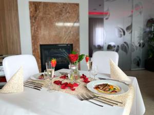 una mesa blanca con platos de comida. en Hotel Ponteo - Activity Park, en Bratislava