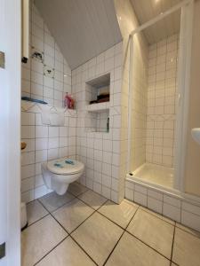 a white bathroom with a toilet and a shower at vakantie appartement Stadskanaal in Stadskanaal