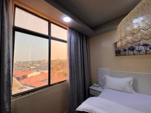 ジュバにあるEASTERN PLAZA HOTELの窓と景色を望むベッドが備わる客室です。