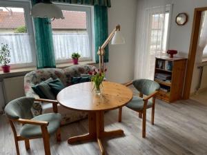 ein Wohnzimmer mit einem Tisch, Stühlen und einem Sofa in der Unterkunft Ferienwohnungen Müller in Bad Staffelstein