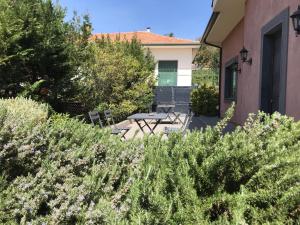 un patio con mesa y sillas en un jardín en B&B La Rena Rossa en Nicolosi