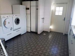 a laundry room with a washing machine and a door at Gula Villan in Gothenburg
