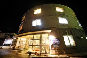 a round building with windows and lights on at HOTEL 24sweets HAKUBA in Hakuba