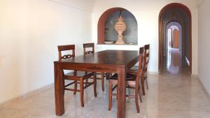 una mesa de madera y sillas en un comedor en Sea View, Nature & Barbecue - Authentic "Dammusi", en Pantelleria