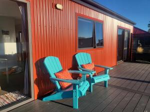 two chairs sitting on the deck of a house at Rough Ridge Cottage ~ your haven in Central Otago in Oturehua +4 photos