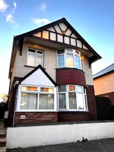 a brick house with large windows on a street at 4 Bedroom House near City Centre with Parking in Gloucester