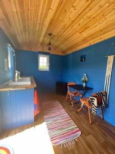a kitchen with a sink and a table in a room at Shepherds Hut - Brecon Beacons in Llangadog