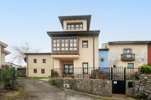 ein Gebäude mit einem Turm auf einer Steinmauer in der Unterkunft Casa el Balandro de Poo in Llanes