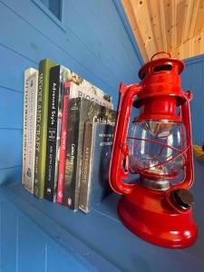 a red lantern sitting on a shelf with books at Shepherds Hut - Brecon Beacons in Llangadog