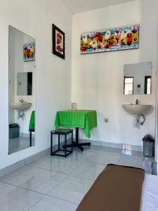 a bathroom with two sinks and a green table at MULIA INN Denpasar Imam Bonjol in Seminyak