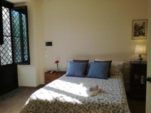 a bedroom with a bed with blue pillows and a window at Tenuta del Gelso in Catania