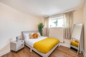 a bedroom with a bed with a yellow blanket at River View 2 Bed 2 Bath Flat - London City Airport, Excel, Pontoon Dock in London