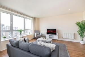 a living room with a couch and a tv at River View 2 Bed 2 Bath Flat - London City Airport, Excel, Pontoon Dock in London