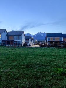 a group of houses in a field with mountains in the background at Holiday house DOMa Nová Lesná in Nová Lesná