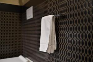 łazienka z białymi ręcznikami wiszącymi na ścianie w obiekcie Palazzo Bovio - Boutique Apartments w Padwie