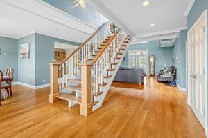 a staircase in a living room with blue walls at Lake Charles Luxe: Casino Escape in Lake Charles