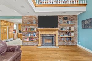 a living room with a brick fireplace with a flat screen tv at Lake Charles Luxe: Casino Escape in Lake Charles