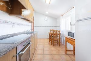 a kitchen with a sink and a stove top oven at Antiga escola Pla del Sabater in Culla