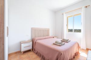 a bedroom with a pink bed and a window at Antiga escola Pla del Sabater in Culla