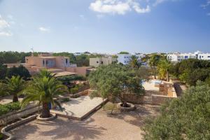 a resort with a pool and palm trees and buildings at Can Granada in Es Pujols