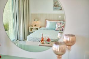 een slaapkamer met een bed en een spiegel bij Lefkimmiatis Villas Corfu in Afionas