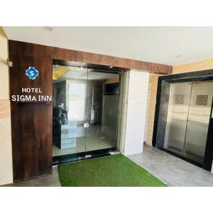 an entrance to a hotel sigina inn with a glass door at Hotel Sigma in Ahmedabad