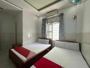 two beds in a small room with a window at SPOT ON 899 Bao Ngan in Da Nang