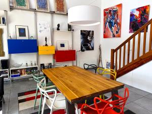 a dining room with a wooden table and colorful chairs at Les Galets - Duplex avec jardin - 2 chambres et bureau in Pau