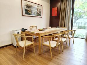 uma sala de jantar com uma mesa de madeira e cadeiras em Yiho Hotel Xiamen Huli em Xiamen