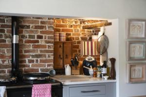 cocina con pared de ladrillo y fogones en Fabulous Farmhouse in Hampshire, en Londres