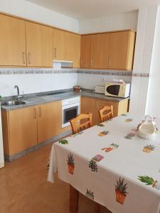 a kitchen with a table with a white tablecloth on it at APARTAMENTOS CANADA 2 in Raxó