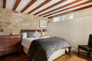 1 dormitorio con cama y pared de piedra en Fabulous Farmhouse in Hampshire, en Londres