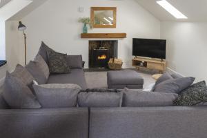 a living room with a gray couch and a fireplace at Stroan in New Galloway
