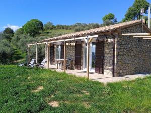 una casa de piedra con mesa y sillas en un campo en Casa vacanze in pietra Il Nibbio Reale, en Semproniano