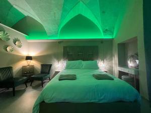 een slaapkamer met groene verlichting op het bed bij Siramà Suite Deluxe in Oria