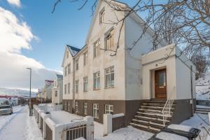 a large white building with snow on the ground at Day Dream Central Akureyri Three Bedroom Apt in Akureyri