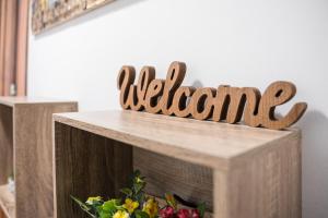 una señal de madera que dice bienvenida en la parte superior de una mesa en GuestReady - A brilliant stay near Alma Mall, en Coímbra