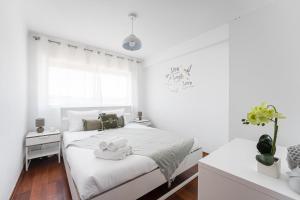 una camera bianca con un letto e una finestra di GuestReady - A brilliant stay near Alma Mall a Coimbra