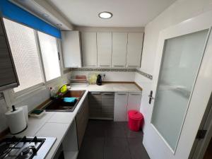 a small kitchen with white cabinets and a sink at RMN Tavernes in Tabernes Blanques