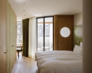 a bedroom with a bed and a large window at kleiner Löwe – Stadthotel Bregenz in Bregenz