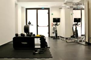 a gym with treadmills and machines in a room at Palazzo Cartari in Palermo