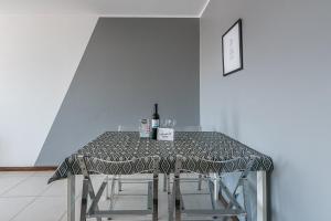 a table with a bottle of wine on top of it at GuestReady - Espinho Beach Flat in Espinho
