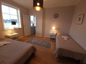 a bedroom with two beds and two lamps and a window at Gula Villan in Gothenburg