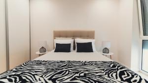 a bed with black and white sheets and pillows at GuestReady - Glamorous getaway in Coimbra in Coimbra