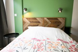 a bed with a white comforter with flowers on it at Central Part-Dieu - Appartement 1 in Lyon