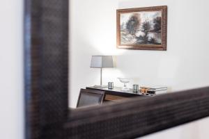 Spiegelreflexion eines Schreibtisches mit einer Lampe und einem Bild in der Unterkunft GuestReady - Espinho Lux in Porto