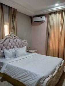 una camera da letto con un grande letto e un copriletto bianco di Agoms Hotel 