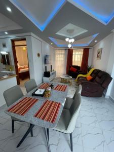a living room with a table and chairs and a couch at Ankar Homes, California 2 in Nanyuki
