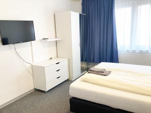 a hotel room with a bed and a tv at Haus Hanseatic in Helgoland