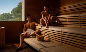 two men sitting on a bed in a sauna at Aminess Vival Maestral Hotel in Novigrad Istria